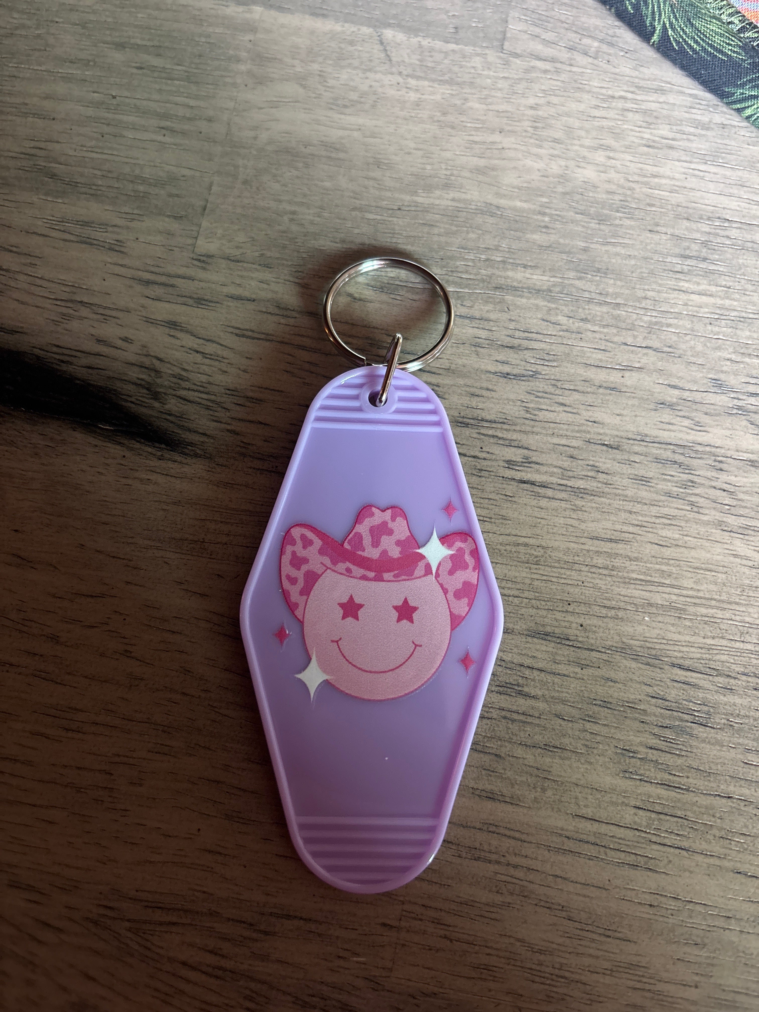 Pink smiley in hat motel keychain